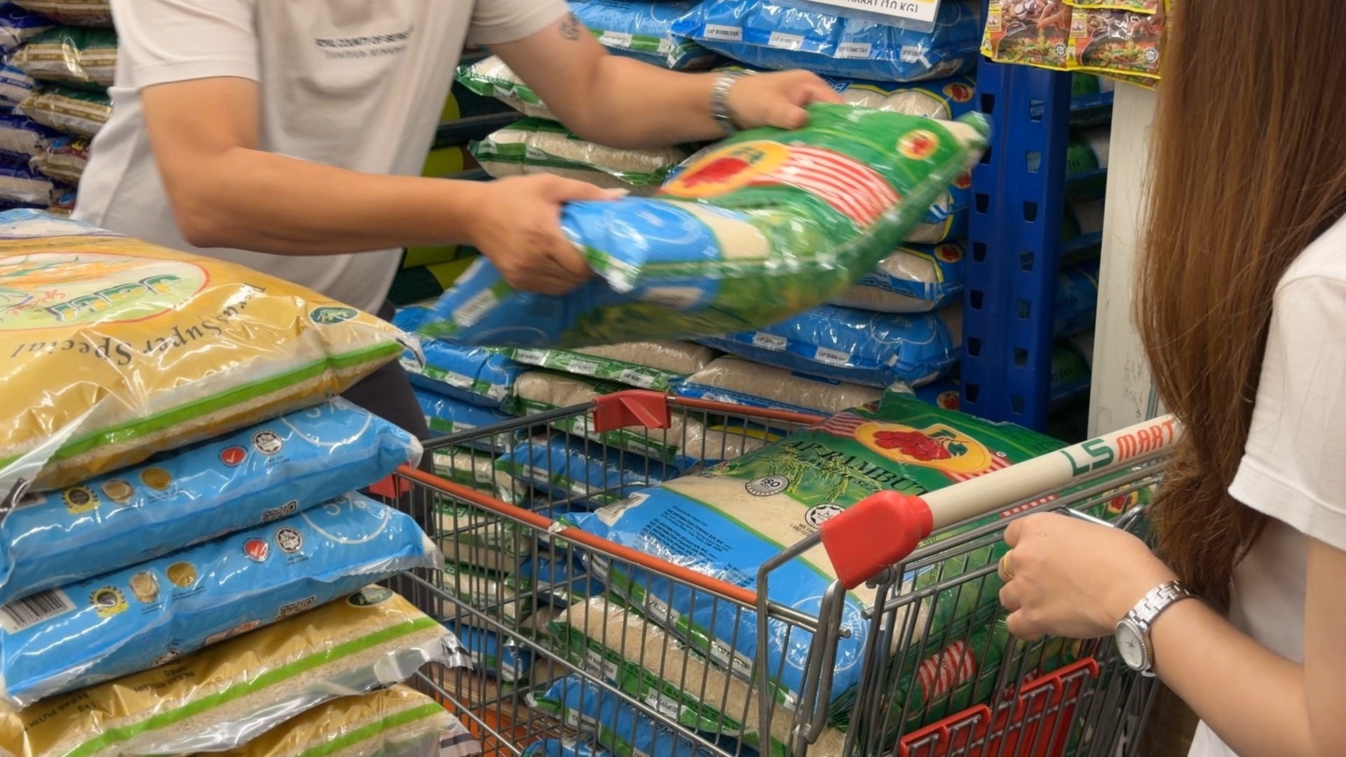 Loading rice into a shopping cart to prepare supplies for the visit.